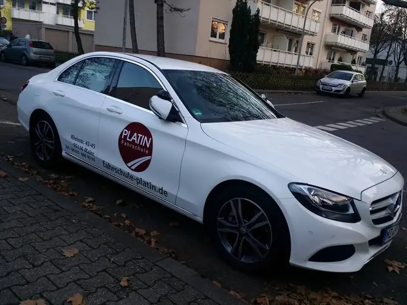 Weiße Mercedes C-Klasse mit der roten Kreis-Marke der früheren Beschriftung