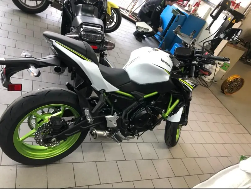 Weiße Kawasaki Z650 mit grünen Felgen in einer Werkstatt